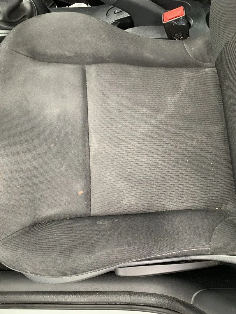 Assise de siège de voiture en tissu, poussiéreuse et tachée, avant nettoyage
